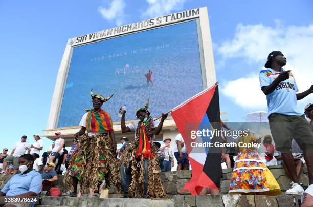 Antigua dancers dance with England fans during day three of the first test match between West Indies and England at Sir Vivian Richards Stadium on...