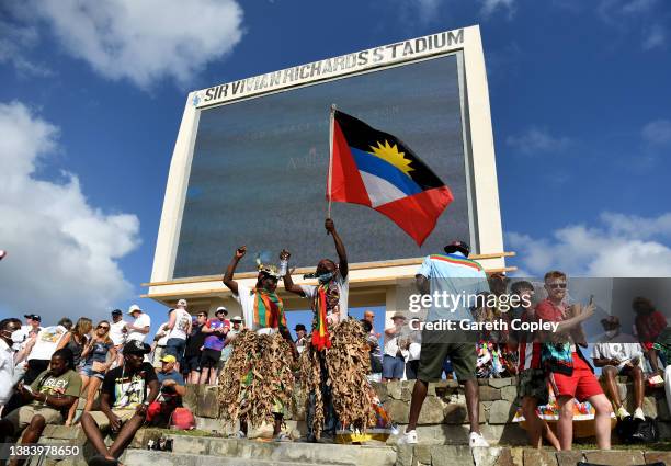 Antigua dancers dance with England fans during day three of the first test match between West Indies and England at Sir Vivian Richards Stadium on...