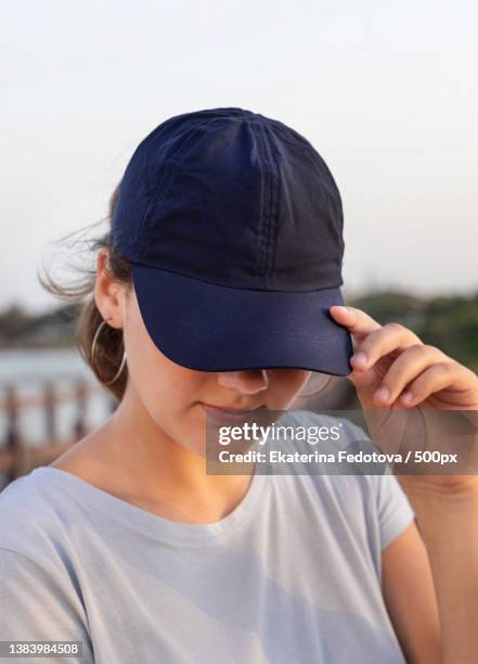 teen girl in dark blue baseball cap and t-shirt - editorial template stock pictures, royalty-free photos & images