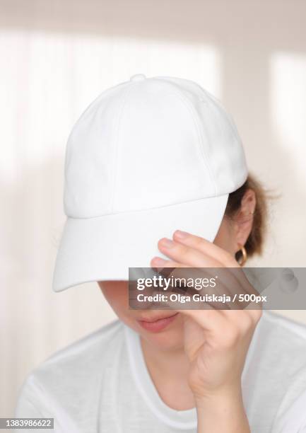 female model wearing a white baseball cap white cap mockup - editorial template stock pictures, royalty-free photos & images