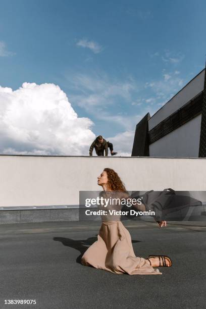 young man and woman on the modern rooftop in the sun - girl dress romantic stock-fotos und bilder