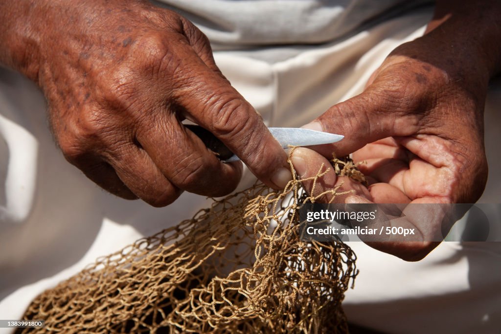 Fishermans hand repairing a fishing net Province Sucre,Sucre,Venezuela