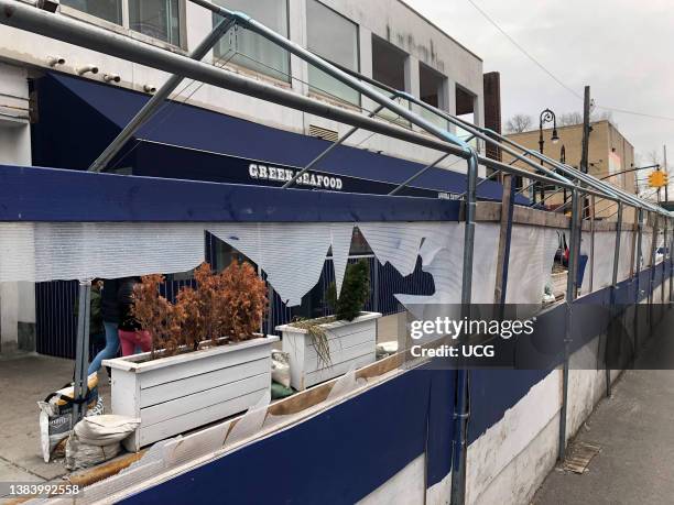 Covid 19 pandemic outdoor dining shelter that's showing signs of damage and wear and tear due to age lack of use and weather conditions, Queens, New...