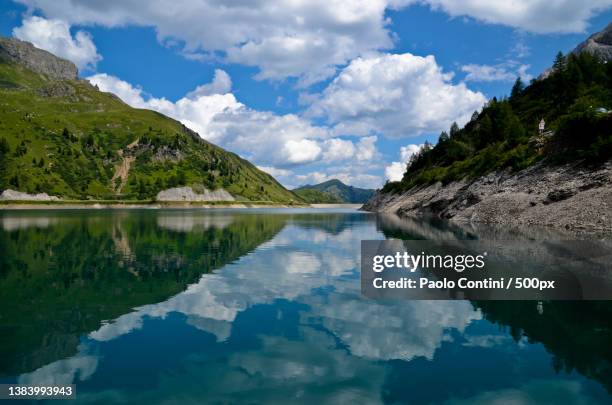 scenic view of lake and mountains against sky,lago di fedaia,canazei,trento,italy - canazei stock-fotos und bilder