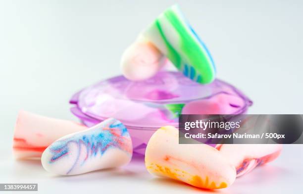 earplugs of different colors on a white background - schwimmer freisteller stock-fotos und bilder