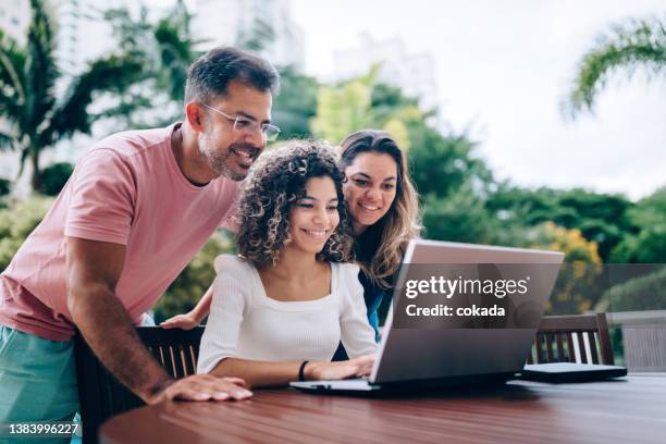 famiglia che utilizza il computer portatile nell'area di riposo - parent foto e immagini stock