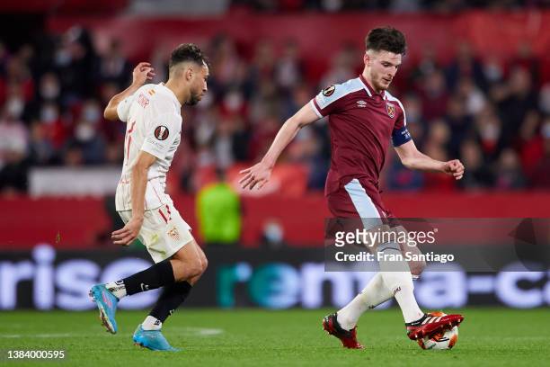 Declan Rice of Sevilla FC competes for the ball with Munir El Haddadi of West Ham United during the UEFA Europa League Round of 16 Leg One match...
