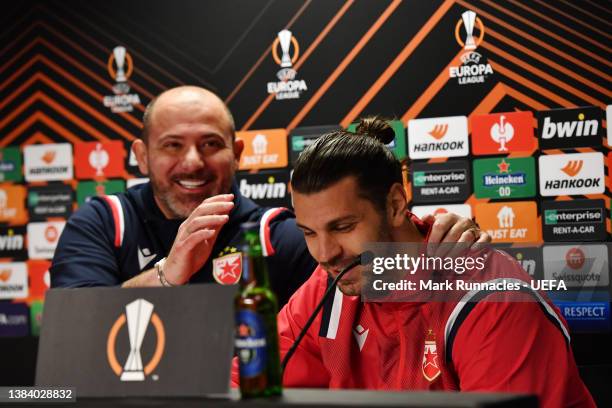 Dejan Stankovic, Head Coach of Crvena Zvezda and Aleksandar Dragovic of Crvena Zvezda share a joke during a press conference following their defeat...