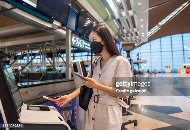 geschäftsfrau, die den self-check-in-automaten am flughafen benutzt, um die bordkarte zu erhalten - kuala lumpur airport stock-fotos und bilder
