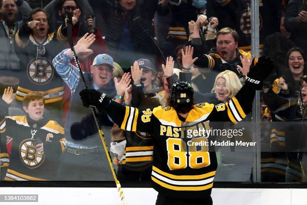 David Pastrnak of the Boston Bruins celebrates with fans after scoring the game winning goal against the Chicago Blackhawks during the third period...