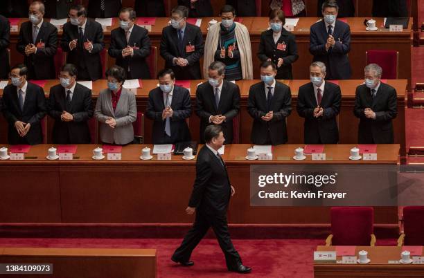 Chinese President Xi Jinping is applauded by members of the government as he arrives for the closing session of the National People's Congress at the...