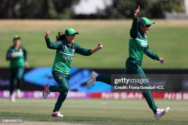 Ghulam Fatima and Bismah Maroof of Pakistan celebrate after taking the wicket of Mignon du Preez of South Africa during the 2022 ICC Women's Cricket...