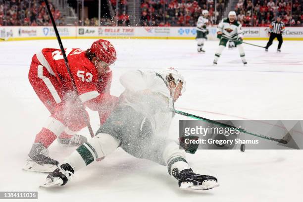 Kirill Kaprizov of the Minnesota Wild battles for the puck against Moritz Seider of the Detroit Red Wings during the third period at Little Caesars...