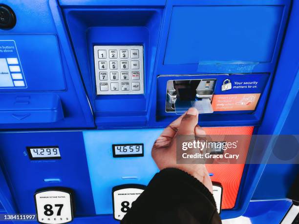 woman purchases gas at pump - card reader stockfoto's en -beelden