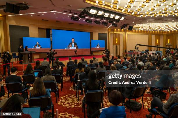 Chinese Premier Li Keqiang is seen on screens in the media center as he speaks from inside the Great Hall of the People, during his annual press...