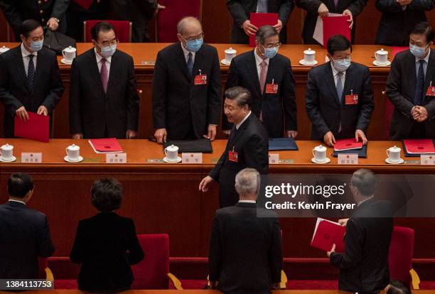 Chinese President Xi Jinping reacts as he passes senior members of the government at the end of the closing session of the National People's Congress...