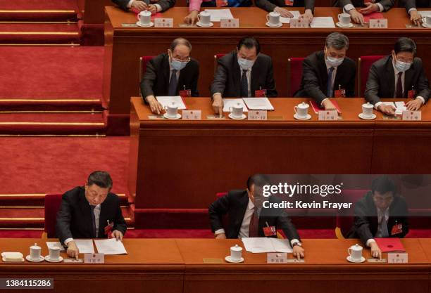 Chinese President Xi Jinping and Premier Li Keqiang and other members of the government vote at the closing session of the National People's Congress...