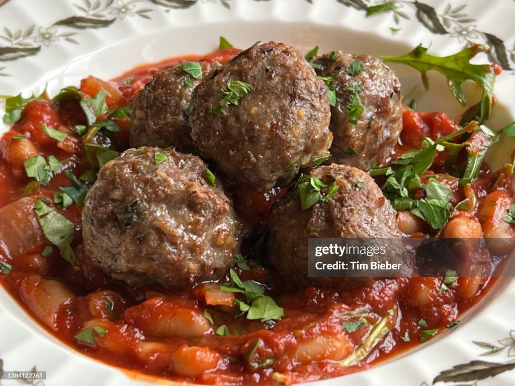 Meatballs in a hearty stew of beans and tomato.