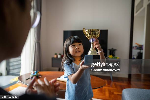 daughter showing trophy to father - asian championship bildbanksfoton och bilder