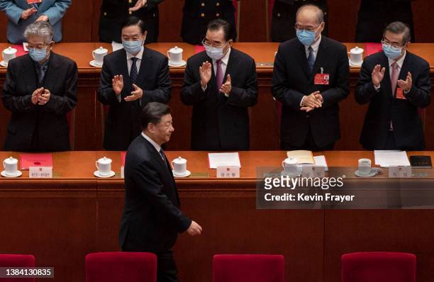 Chinese President Xi Jinping is applauded by members of the government as he arrives for the closing session of the National People's Congress at the...