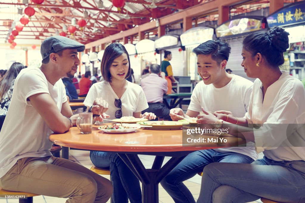 Group of friends having a meal at Maxwell hawker Centre, Singapore