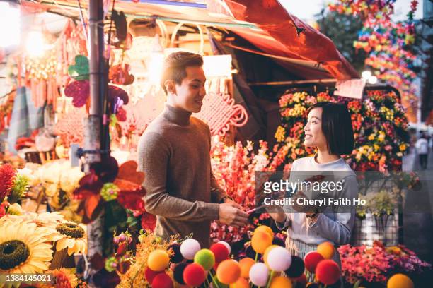 lovely couple shopping in chinatown over chinese new year - chinese prepare for lunar new year stock pictures, royalty-free photos & images