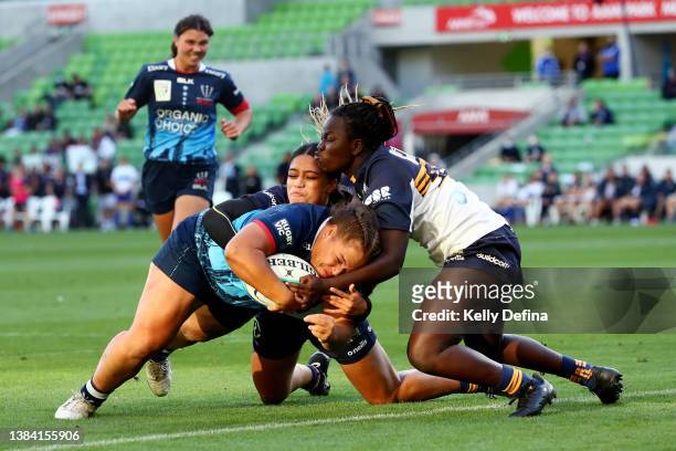 Ashley Marsters of the Rebels scores a try under defensive pressure from Biola Dawa of the Brumbies during the round two Super W match between the...