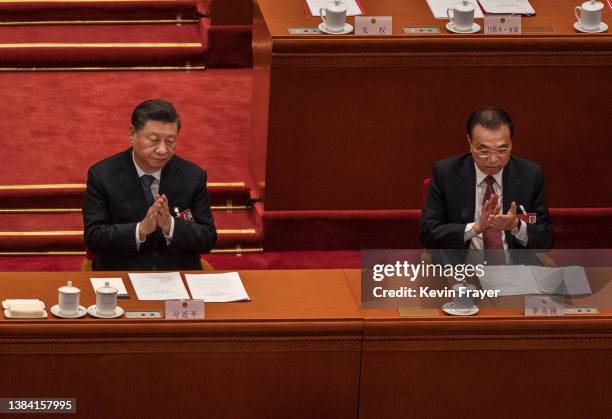 Chinese President Xi Jinping and Premier Li Keqiang applaud at the closing session of the National People's Congress at the Great Hall of the People...