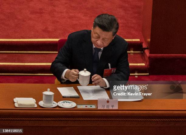 Chinese President Xi Jinping takes his tea cup during the closing session of the National People's Congress at the Great Hall of the People on March...