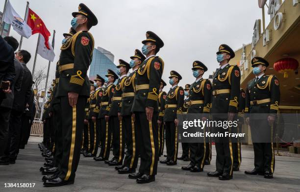 Members of the People's Liberation Army Band gather for a group photo outside a closed loop hotel after playing at the closing session of the...