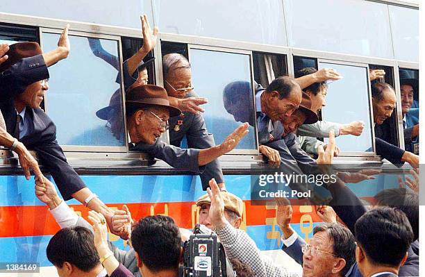 North Koreans stick their arms out from bus windows to hold the hands of their South Korean relatives as they bid farewell following the end of the...