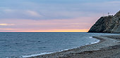 panorama view of La Chucha Beach and the lighthouse of Cabo Sacratif in Andalusia at asunset
