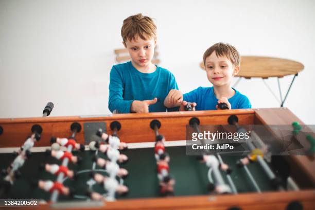 brothers playing table soccer - ball on a table stockfoto's en -beelden