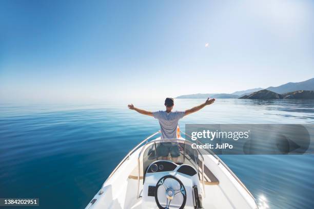 young man riding on speedboat - watervaartuig stockfoto's en -beelden