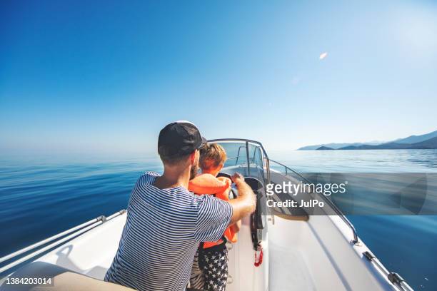 schnellbootfahrt - father son sailing stock-fotos und bilder