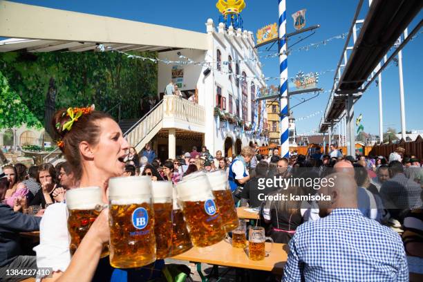 camarera llevando vasos de cerveza en el oktoberfest en munich, alemania - oktoberfest fotografías e imágenes de stock