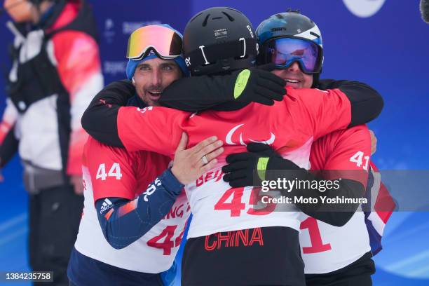 March 11:Ollie Hill of Team Great Britain,Qi Sun of team China and Matti Suur-Hamari of team Finland cerebration for the Men's Snowboard Banked...