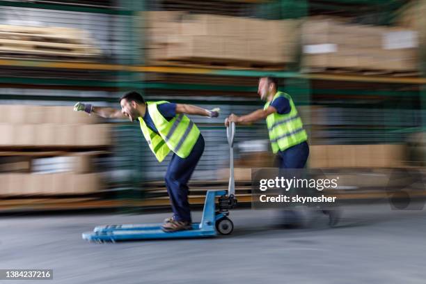 playful workers having fun in distribution warehouse. - ware house worker forklift stock pictures, royalty-free photos & images