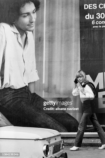 La chanteuse France Gall pose devant une affiche de son conjoint Michel Berger en concert au Théâtre des Champs Elysées, Juillet 1980