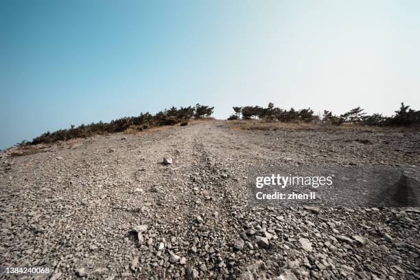 gravel road through mountain range - rough road texture stock pictures, royalty-free photos & images