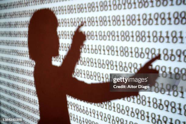 a human shadow touches some numbers with binary code on a surface. - security code 個照片及圖片檔