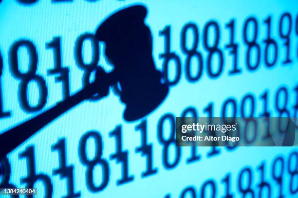 concept of justice: close up of a judge's gavel passing sentence. binary code in the background. - lawsuit stock-fotos und bilder