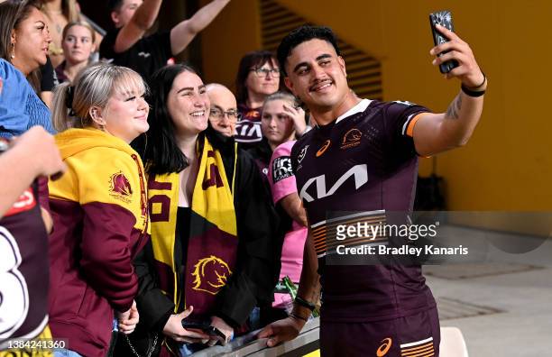 Keenan Palasia of the Broncos get a selfie with fans after the round one NRL match between the Brisbane Broncos and the South Sydney Rabbitohs at...