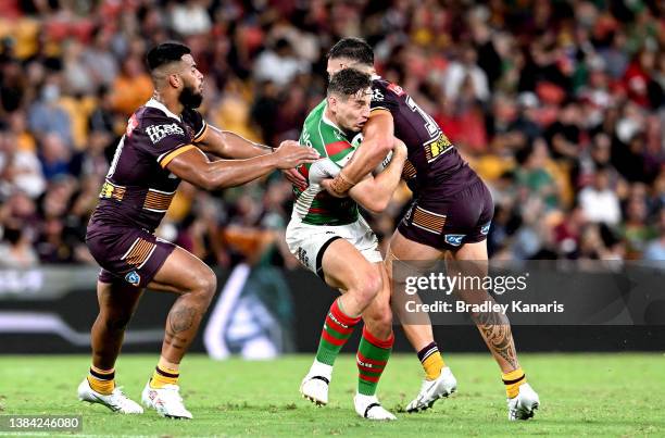 Cameron Murray of the Rabbitohs is wrapped up by the defence during the round one NRL match between the Brisbane Broncos and the South Sydney...