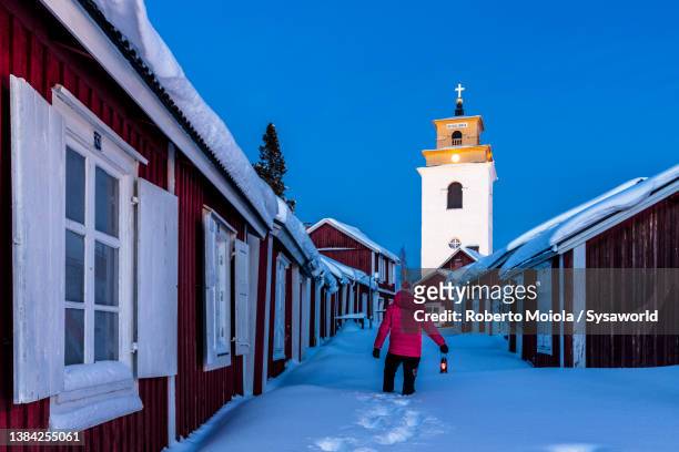 man admiring cottages standing in the snow, lapland - lulea - fotografias e filmes do acervo