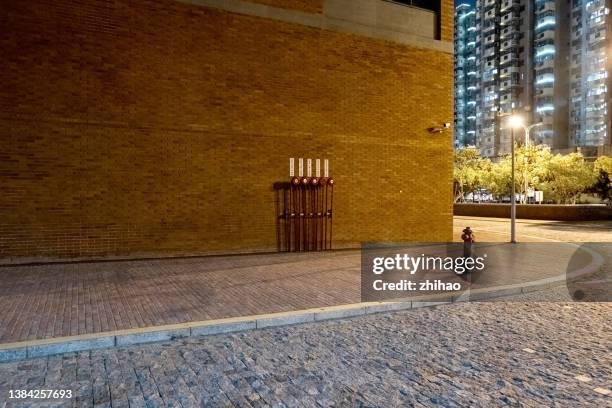 night view of empty footpath with brick wall background - city street fotografías e imágenes de stock