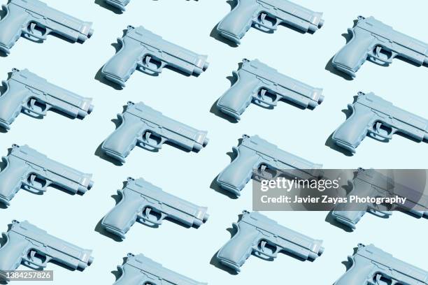 blue handgun on blue background - gun stock-fotos und bilder