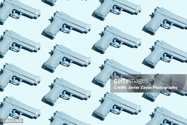 blue handgun on blue background - arme à feu photos et images de collection