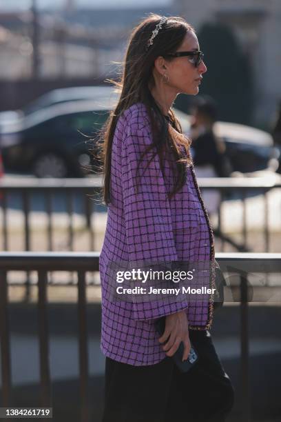 Chloe Harrouche seen wearing black sunglasses, a purple with black checkered print pattern and gold borders jacket from Chanel, a black shiny leather...