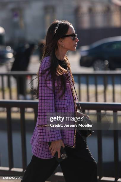 Chloe Harrouche seen wearing black sunglasses, a purple with black checkered print pattern and gold borders jacket from Chanel, a black shiny leather...